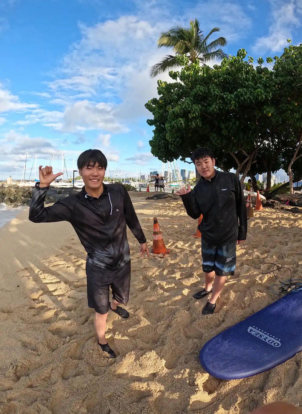 ワイキキ周辺のビーチでサーフィン後、背景に寝ているモンクシールを一緒に写真撮影。